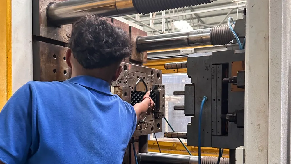 Operator working at an open mould on an injection moulding machine